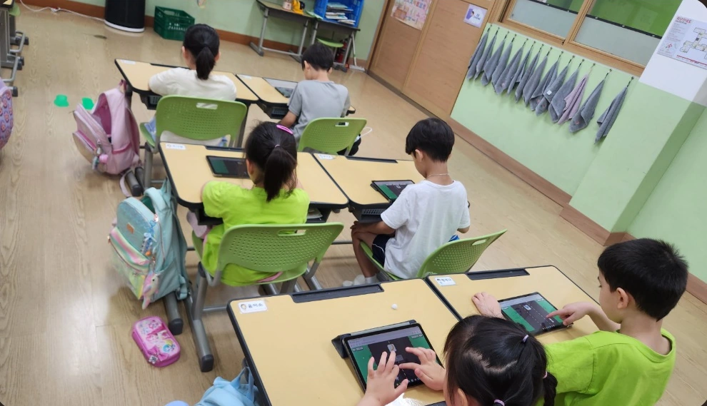교실에서 태블릿으로 글림을 사용해보는 아이들과 선생님
